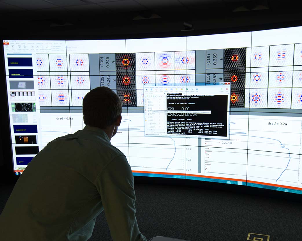 Student works on computer with large screen.