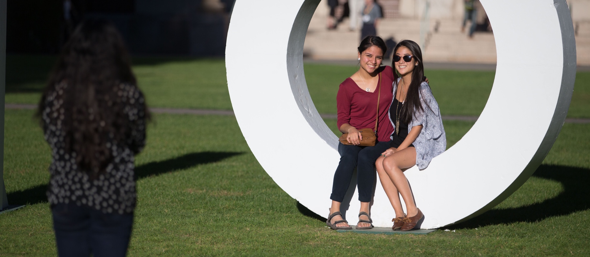 Graduates taking selfie from the top of Rush Rhees Library overlooking University of Rochester