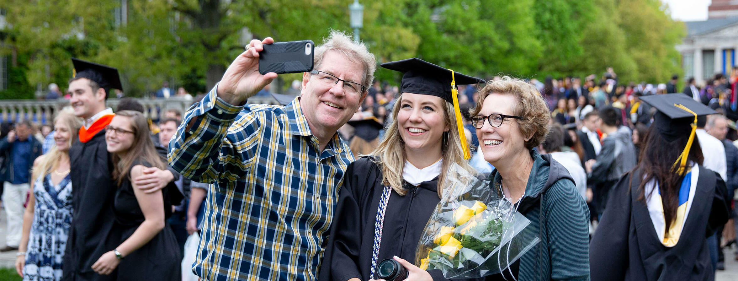 A University of Rochester graduate takes a selfie with her parents during Commencement Weekend, celebrating their achievement.
