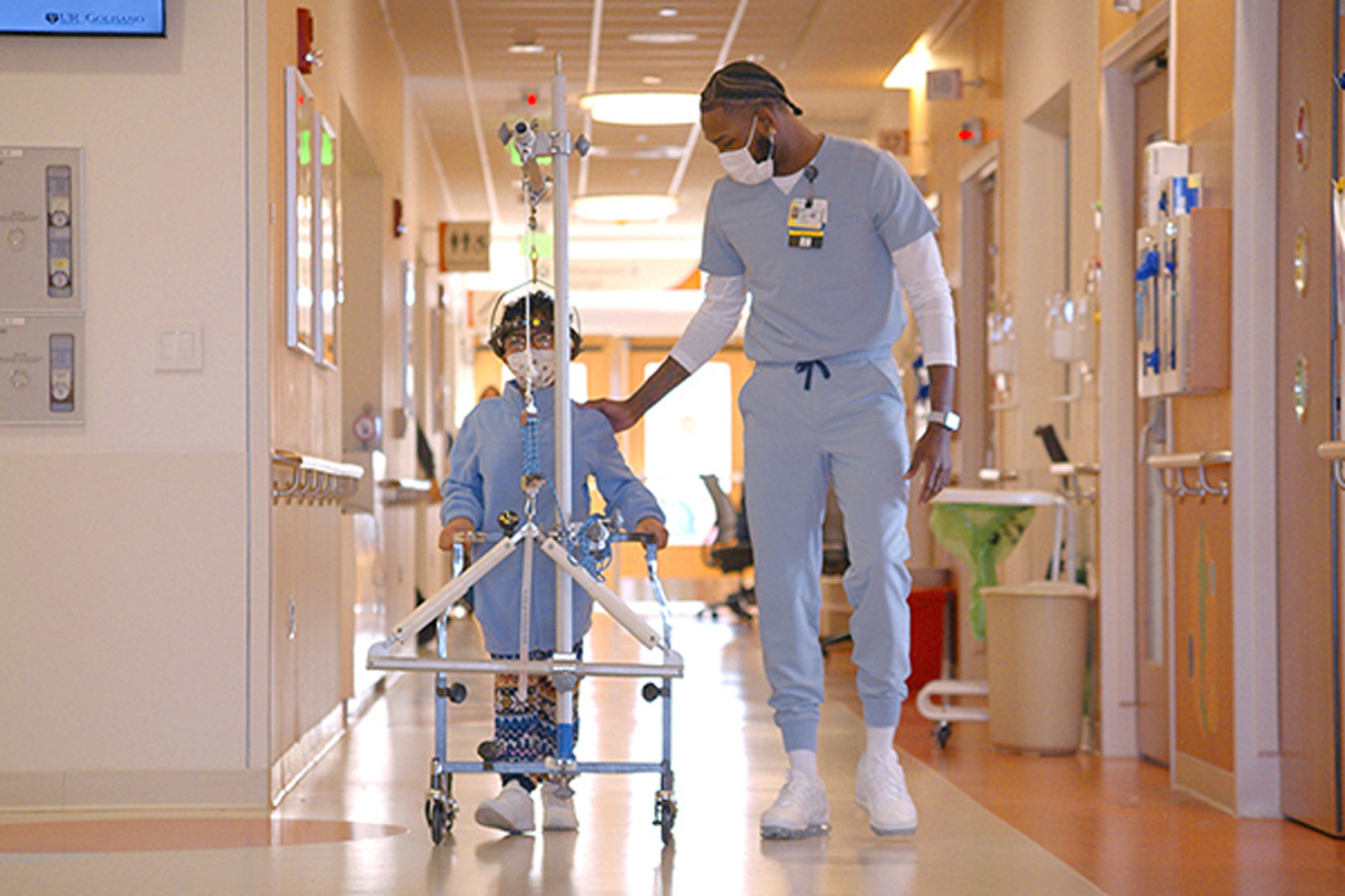A man and a child walking together down a hallway at the University of Rochester Medical Center.
