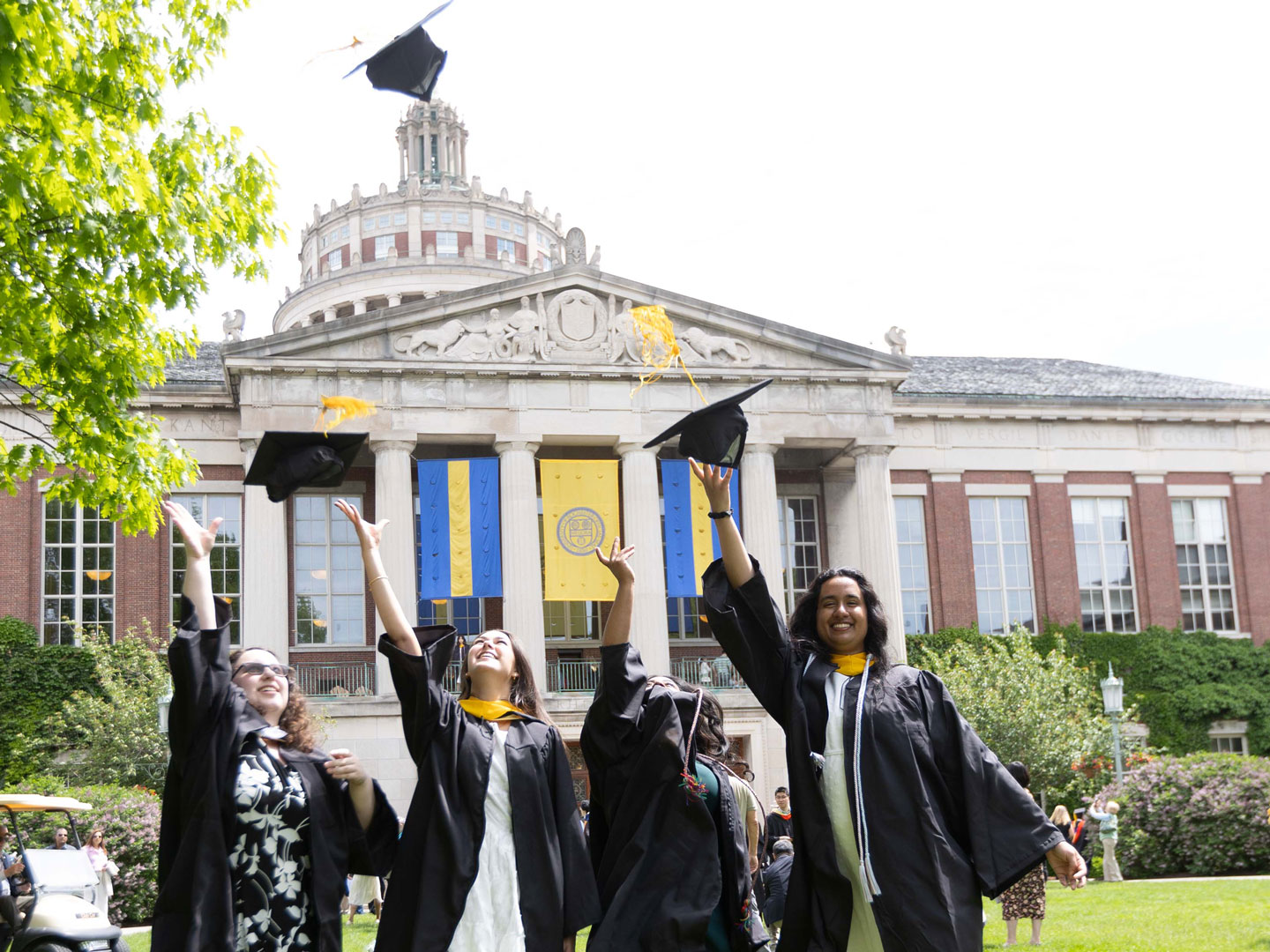 Graduates in traditional gowns and caps joyfully gather to commemorate their graduation at the University of Rochester.
