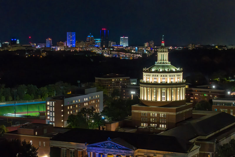 Futuristic digital scene with neon blue rectangles displaying binary code and light beams on a blue and purple background.
