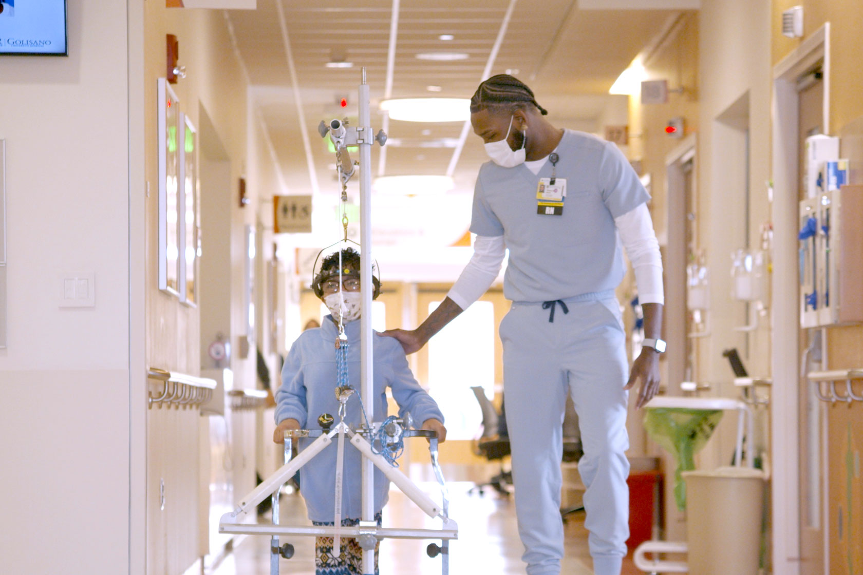 A man and a child walking together down a hallway at the University of Rochester Medical Center.