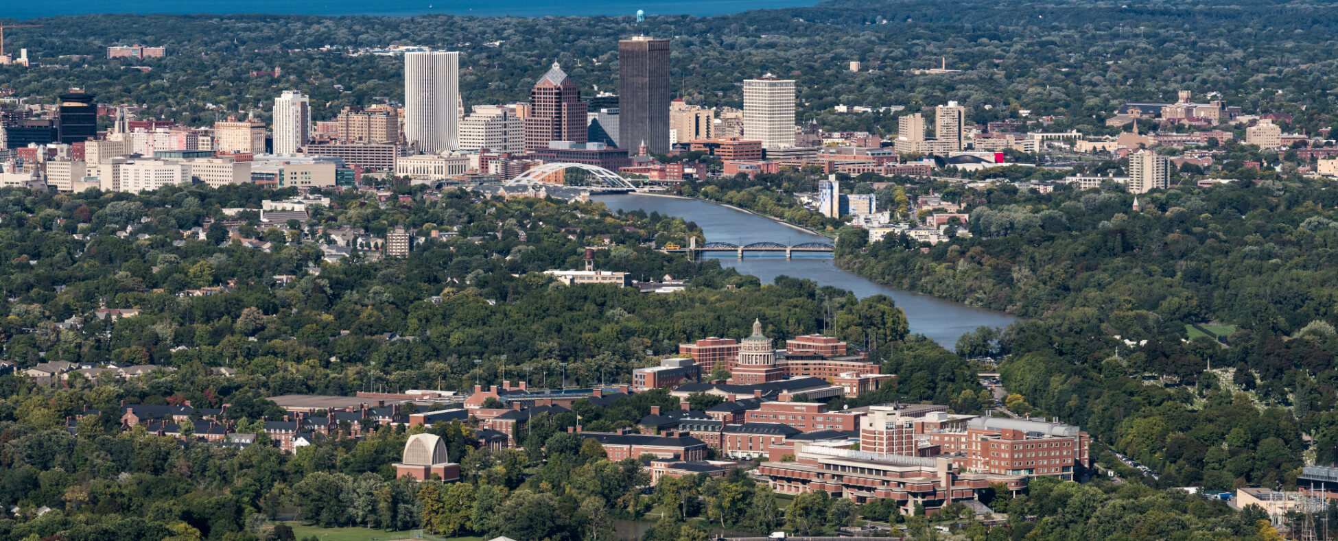 Aerial view of Rochester, NY, showcasing the city skyline with buildings and urban landscape.