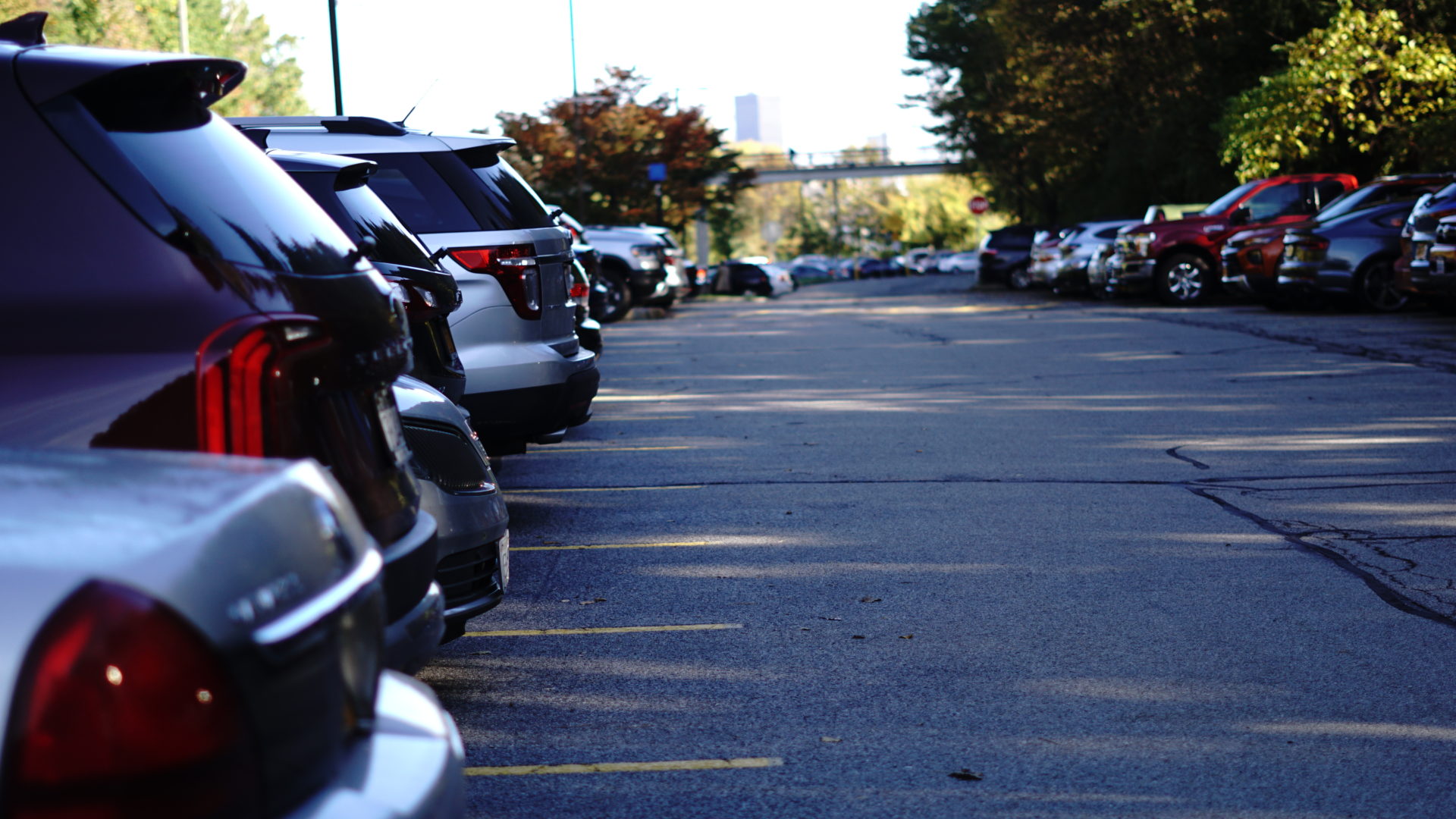 Vehicles parked in University of Rochester lot with bridge in background