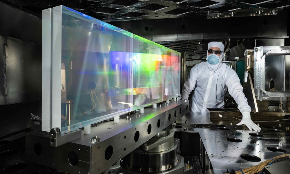 Person in a bunny suit of lab gear with equipment in the Grating Compressor Chamber of the OMEGA EP Laser.