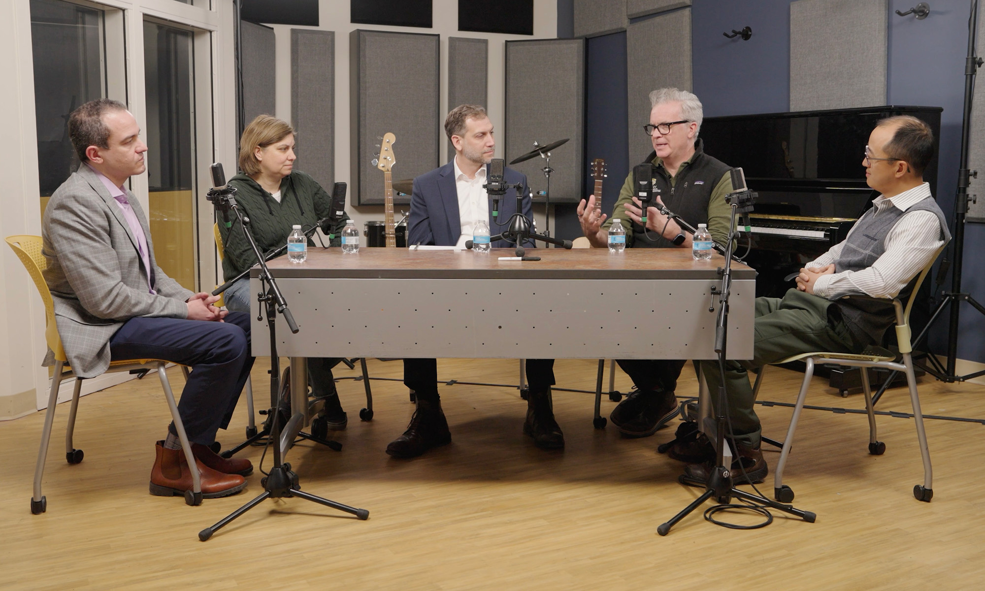 Five University of Rochester faculty sit around a table for a discussion about artificial intelligence, business, and education.