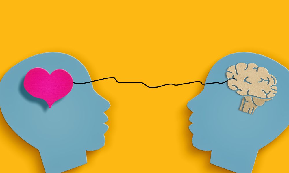 Two human heads with a heart and brain connected, symbolizing the relationship between emotion and intellect.