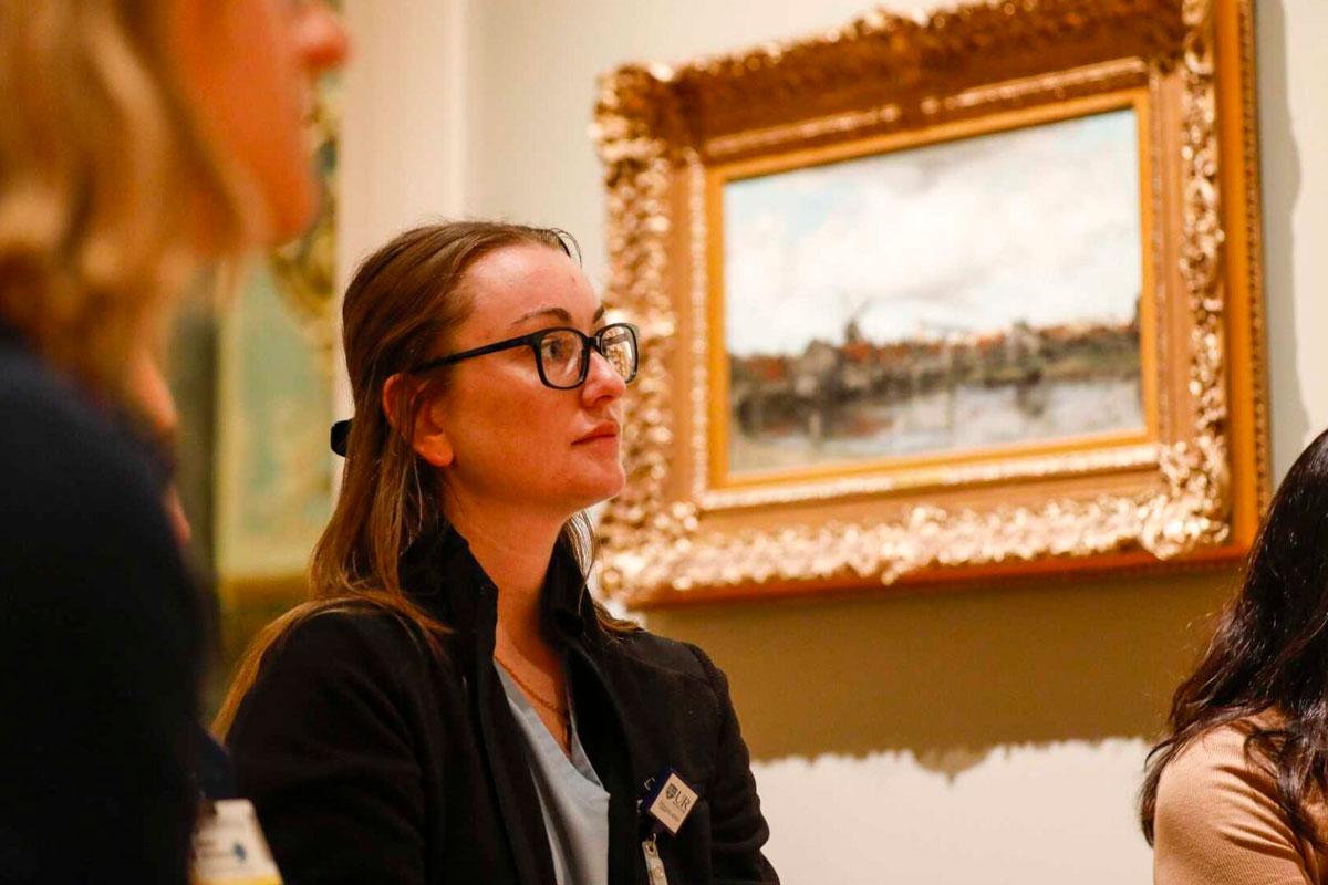 Two women seen from a low angle looking at art in the Memorial Art Gallery.