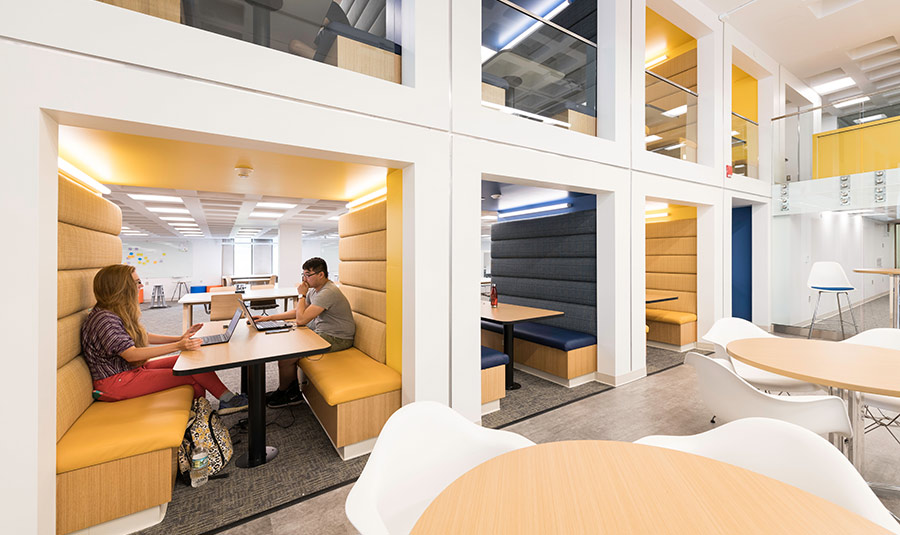 Modern office space in the University of Rochester iZone library featuring yellow and white walls.