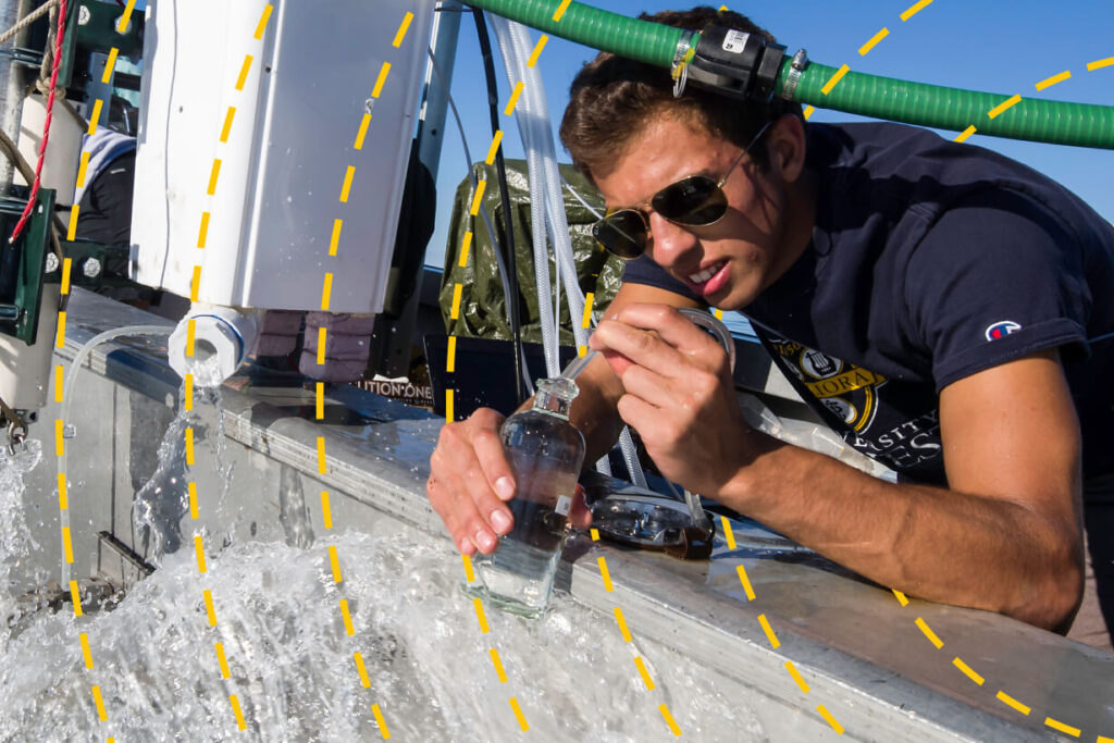 A researcher in the field filling a vial with water