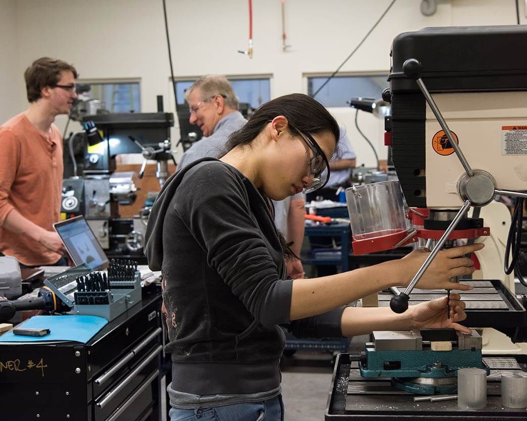 Students using machinery in the Fabrication Lab
